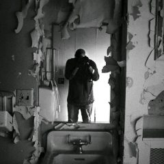 Self-portrait of Joe Polecheck, taken in the staff quarters bathroom inside of Nopeming Sanatorium.